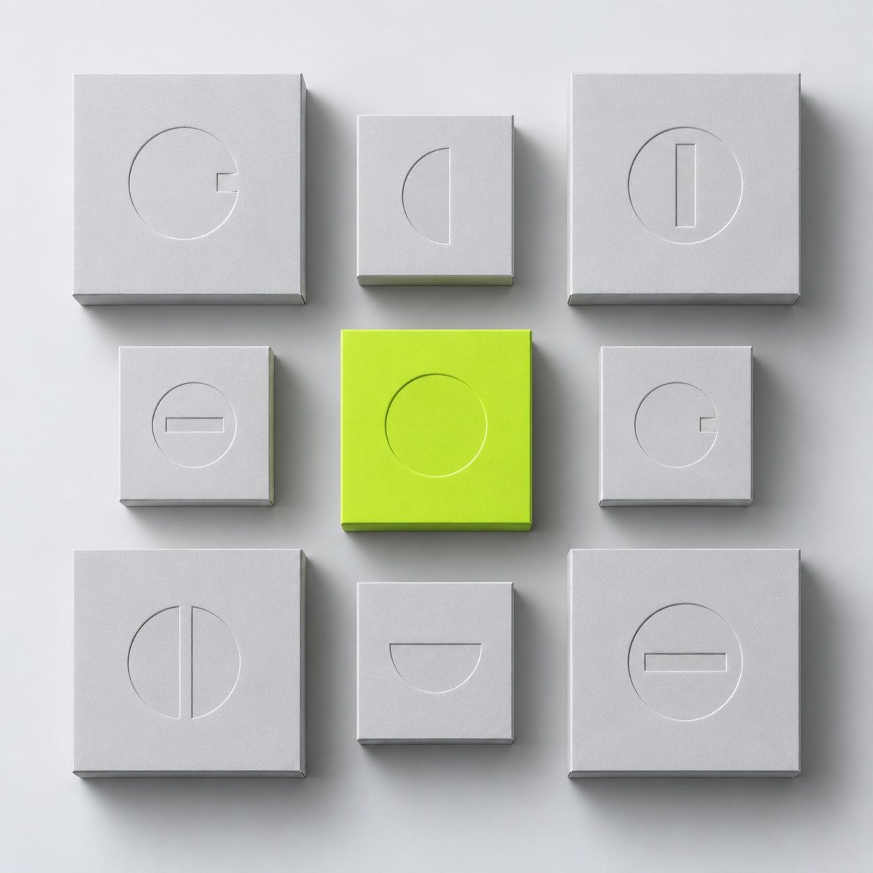 Nine pale grey packaging boxes in a three by three grid, the centre box in acid lime